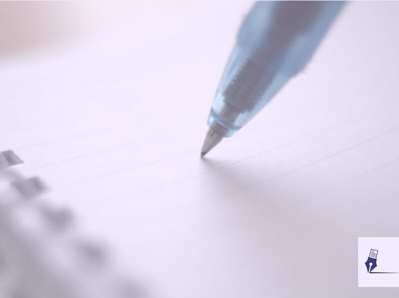 Imagen de la punta de un bolígrafo en una libreta