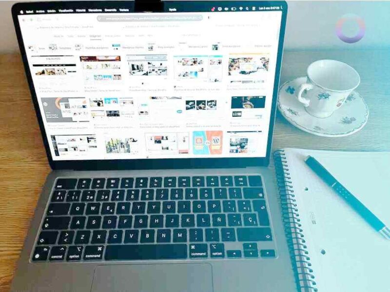 escritorio con portátil, taza de café, libreta y bolígrafo